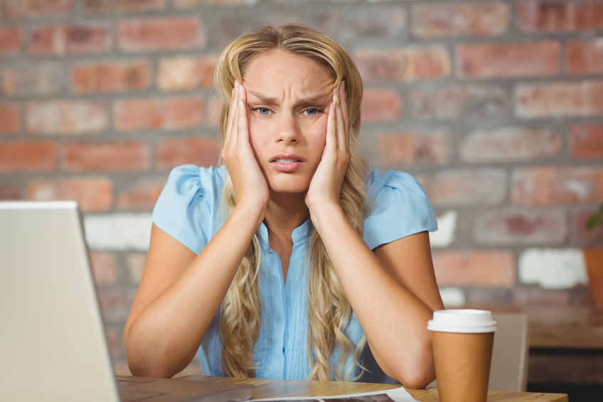 Portrait of frustrated woman sitting in front of her notebook in her office